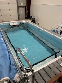 a swimming pool in a garage with a tarp on it