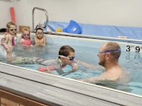 a group of children in a swimming pool with goggles on